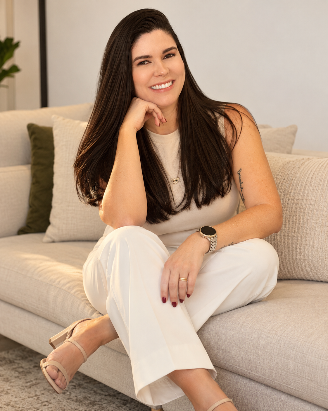 Rafaela Rodrigues, estrategista de marketing, sorrindo sentada em um sofá