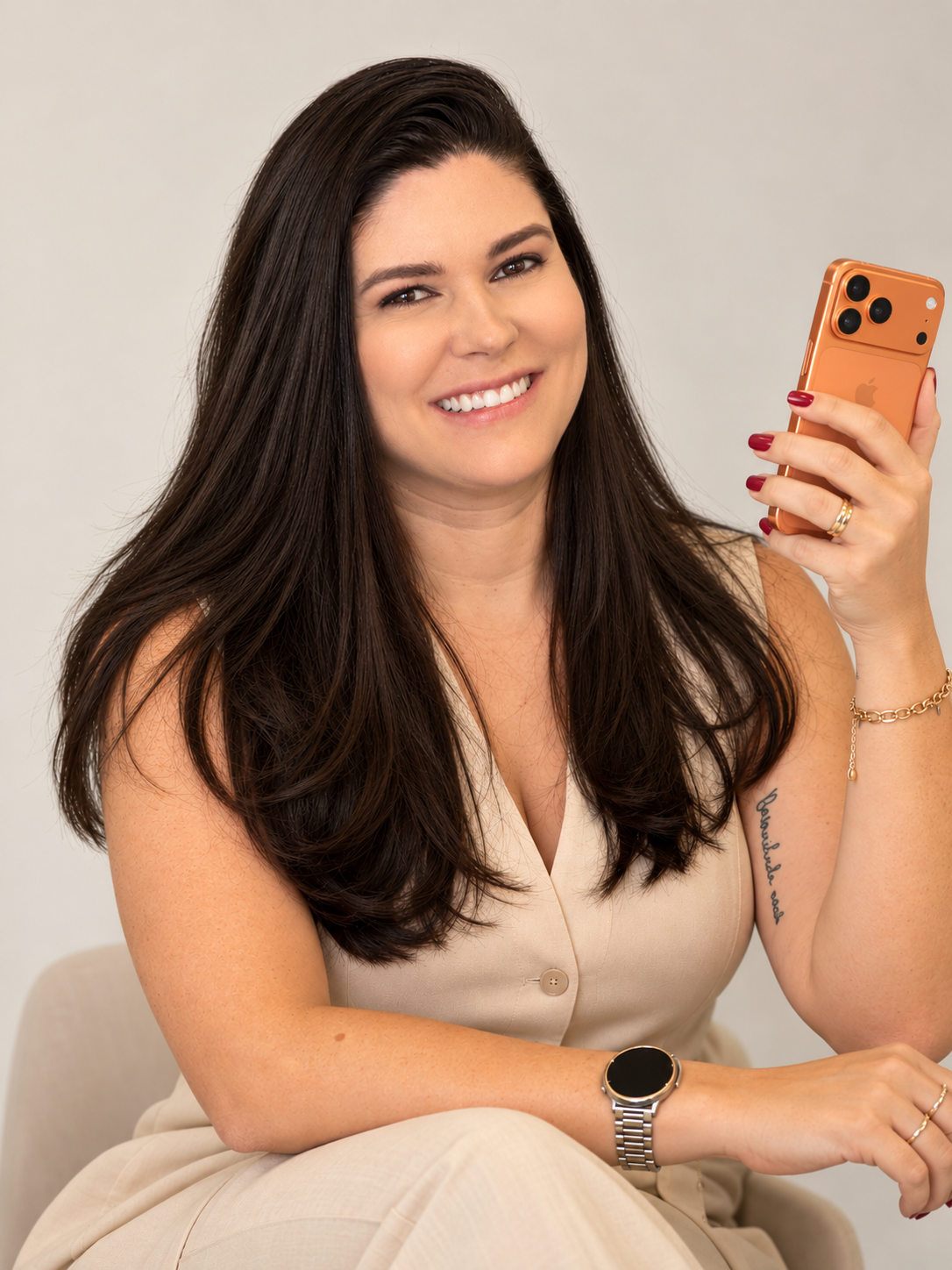 Rafaela Rodrigues sorrindo segurando um celular laranja