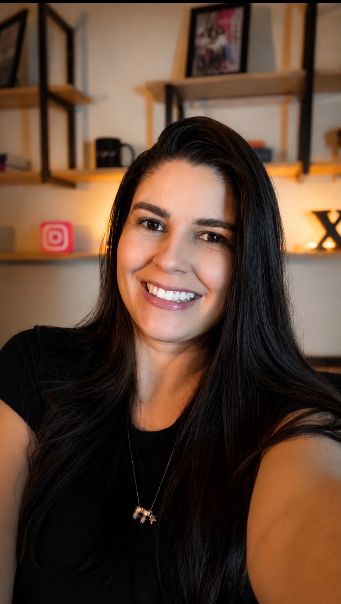 Rafaela Rodrigues sorrindo, de perto, em seu ambiente de trabalho